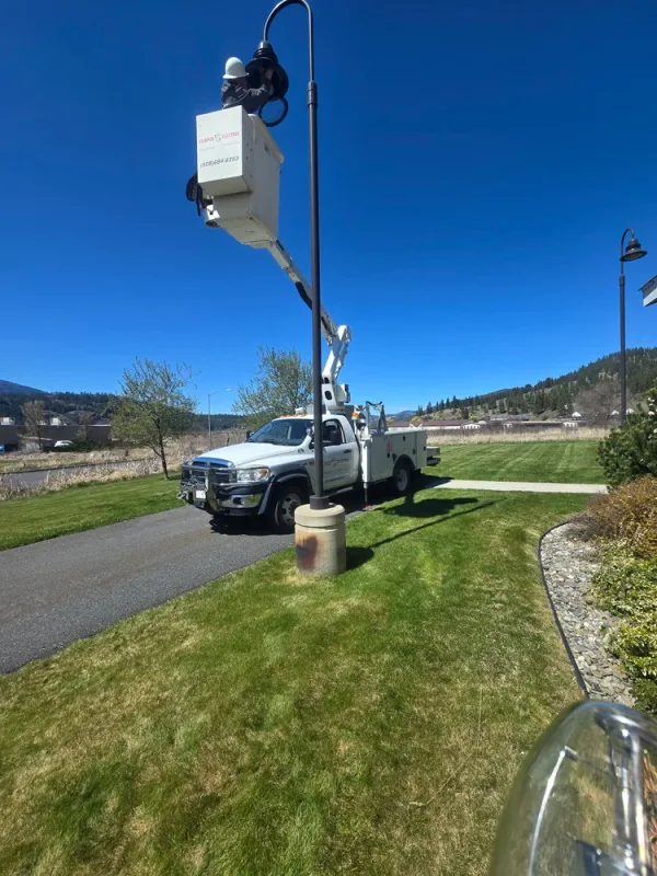 Floener Electric bucket truck servicing a parking lot light pole